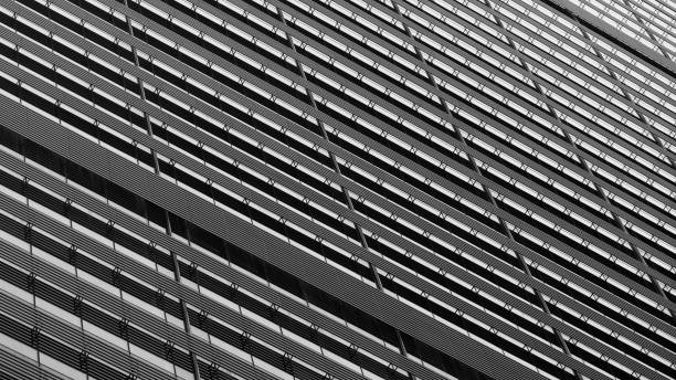 Minimalistic and monochrome architecture shot of skyscraper with series of black lines on a white background, creating a pattern that looks like the facade of a modern building
