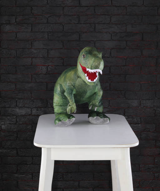 istock toy dinosaur on white table in black room 2200114750