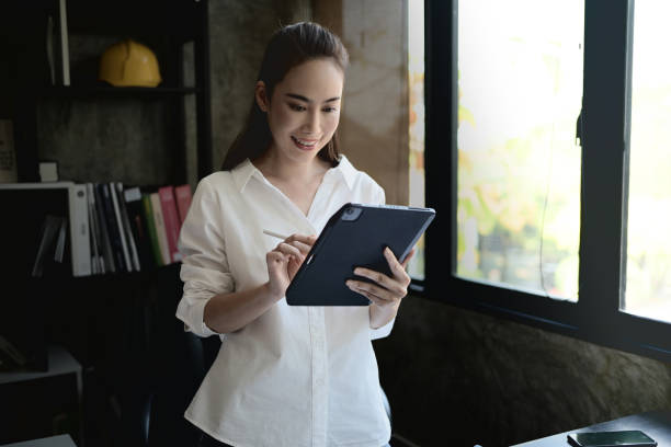 istock A confident Asian female architect or interior designer working on her digital tablet in her office. 2200115774
