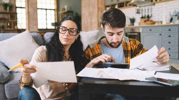 istock Couple calculating bills at home using tablet and calculator. 2200116401