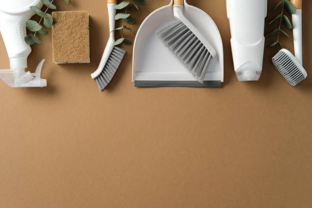 istock Cleaning supplies on a brown background, featuring brushes, sponge, spray bottle, and dustpan. Housekeeping, cleaning services concept 2200116620