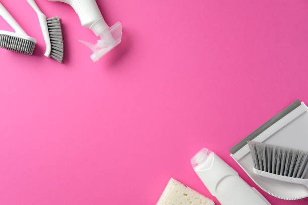 istock Flat lay cleaning supplies on a pink background, including dustpan, brushes, spray bottle, sponge. Perfect for cleaning product articles or ads 2200116834