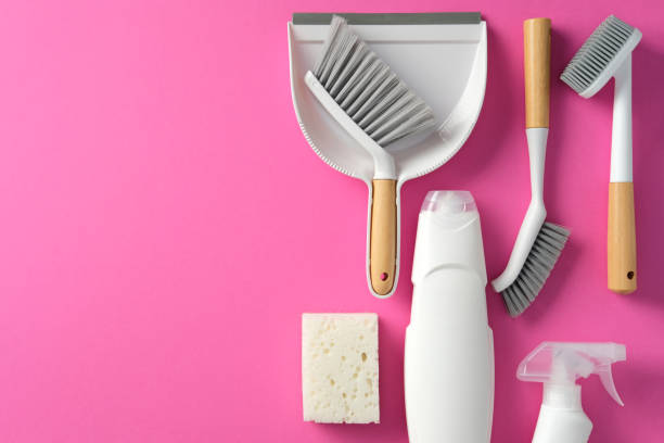 istock Set of eco-friendly cleaning supplies on a pink background. Includes scrub brushes, dustpan, sponge, and spray bottle. Flat lay, top view 2200116856