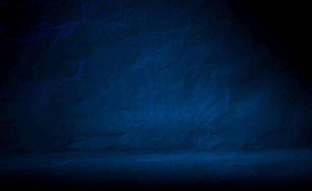 istock Dark concrete wall and floor background with blue lighting for mock up. Minimalist empty dark space with copy space. Three dimensional room backdrop for product display. 2200119526