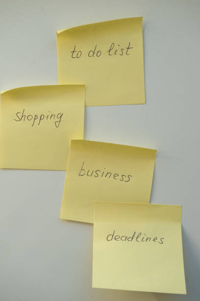 istock Notes reminders of yellow colored stickers with text on the table. Many unfulfilled tasks, deadlines. Top view. 2200119528