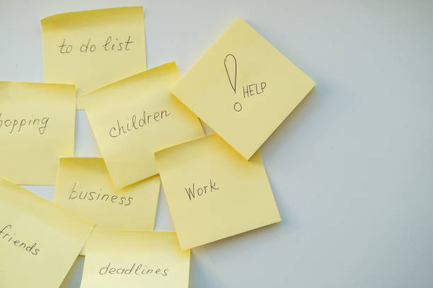 Notes reminders of yellow colored stickers with text on the table. Many unfulfilled tasks, deadlines. Top view