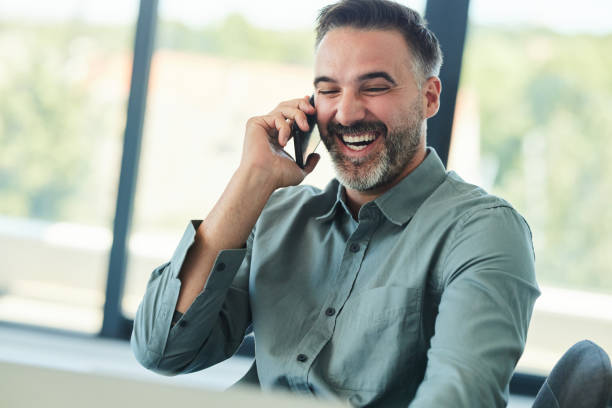 istock Happy businessman talking on cell phone in the office. 2200121162