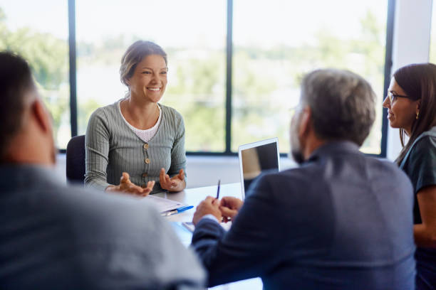 istock Happy female candidate talking to human resource team in the office. 2200121671