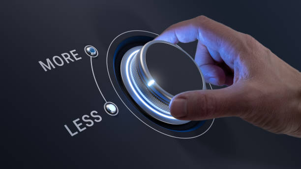 istock Less is More and Quality over Quantity concept with businessman's hand selecting Less on knob. Minimalism, efficiency, streamline, prioritize, effectiveness. 2200121713