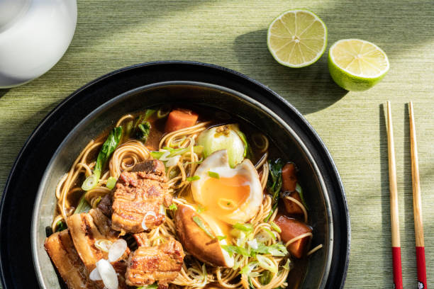 istock Steaming ramen bowl showcasing tender pork belly, soft-boiled egg, crisp vegetables, and savory broth in detailed close-up view 2200124450