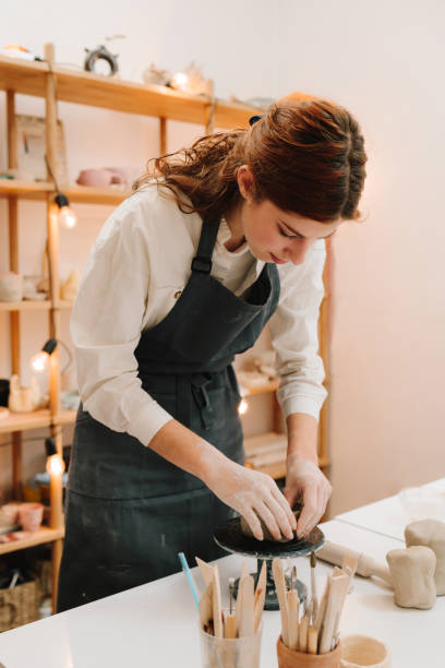 istock Hands shaping clay into dish in the craft studio close-up. Artisan sculpts ceramic bowl using potter's wheel. 2200124553
