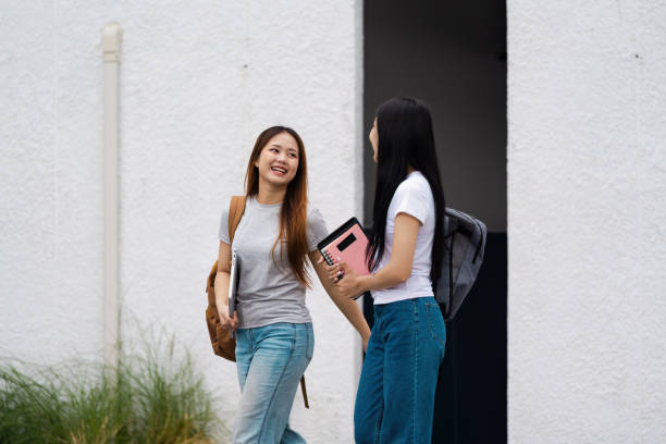 istock Two cheerful students walking together with backpacks, enjoying their time on campus after class 2200124915