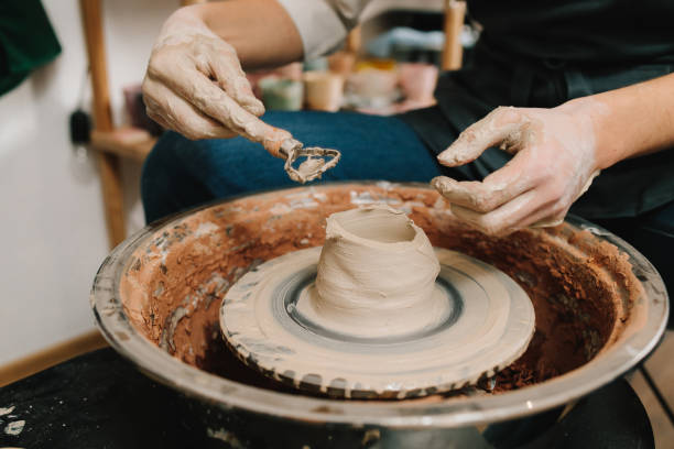 istock Potter sculpts a ceramic mug from clay in the pottery studio. Molding earthenware with potters tools. 2200125211