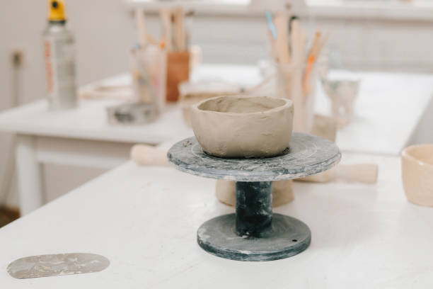 istock Potters wheel with a shaped clay bowl and craft tools in the manufacturing. Sculpted ceramic crockery in the pottery wheel. 2200125230