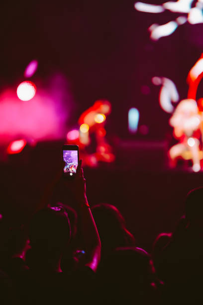 Hand held smart phone filming a concert.  Music festival. Youth, party, vacation concept.