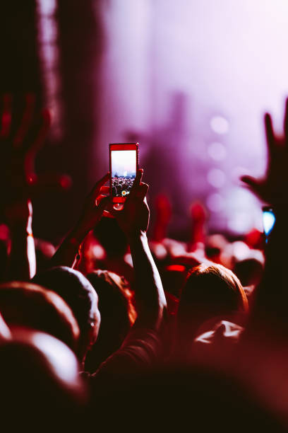 Hand held smart phone filming a concert.  Music festival. Youth, party, vacation concept.