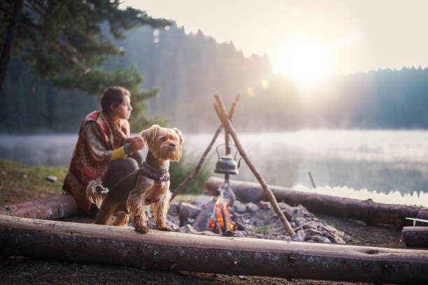 istock Young Female Is Relaxing Next To The Camp Fire And Drinking Tea 2200126878