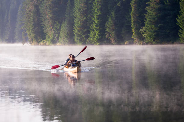 istock Exploring nature together: couple kayaking on a misty lake. 2200126895