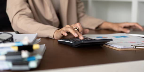 istock Accountant using a calculator to manage financial data and reviewing documents at a desk. 2200130043