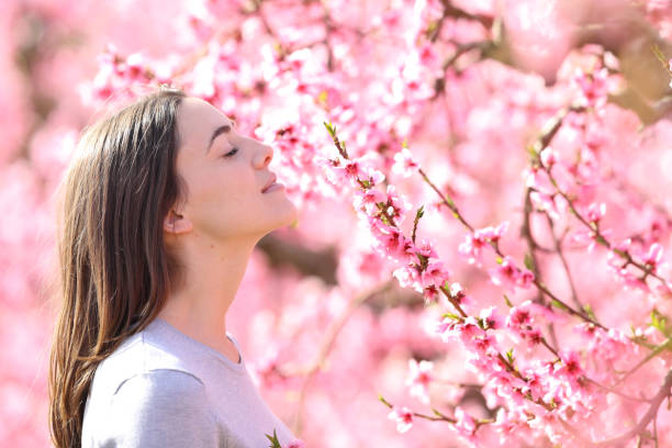 istock Woman smelling flowers in spring field 2200131418