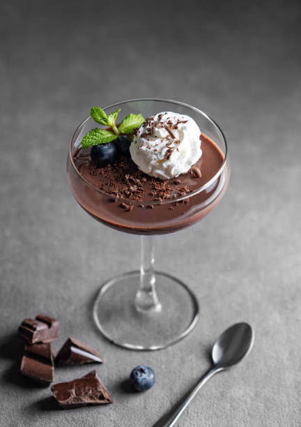 istock Chocolate pudding in a glass with whipped cream, fresh blueberries and mint on a dark background 2200131785