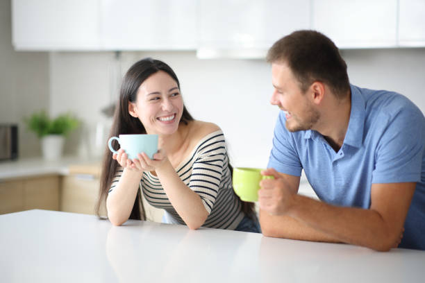 istock Interracial friends drinking and talking in a kitchen 2200131801