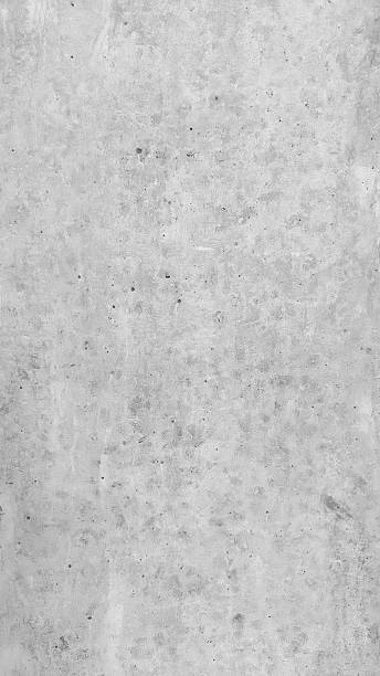 istock Large white grunge textured concrete wall background. The backdrop is a rough cement floor in gray tones. 2200132433