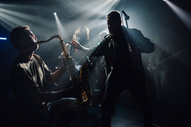 istock Saxophonist and singer performing energetically under stage lights 2200132457