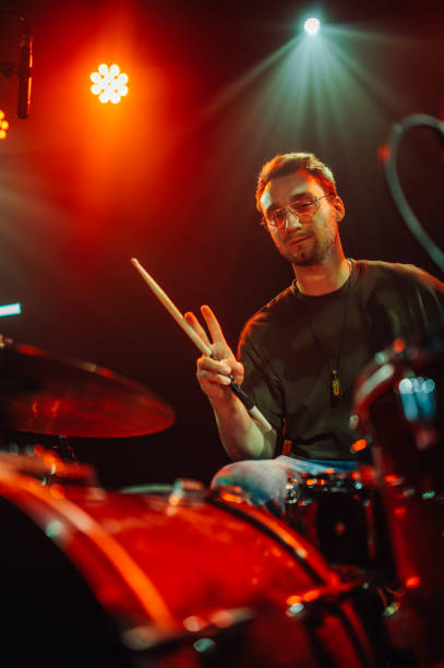 istock Drummer performing live on stage with red lights 2200132515