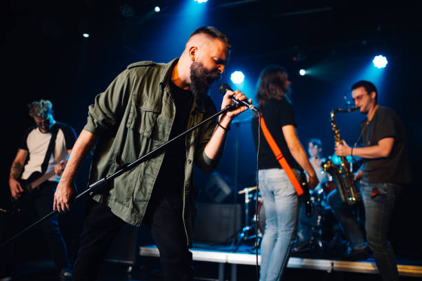 istock Rock band performing live on stage with passionate singer 2200132570