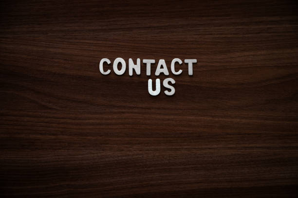 istock Contact us - Wooden letters on walnut background 2200132773