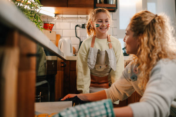Mother and daughter baking cookies together in modern kitchen