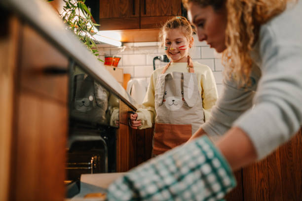 istock Mother and daughter baking cookies together in modern kitchen 2200132974