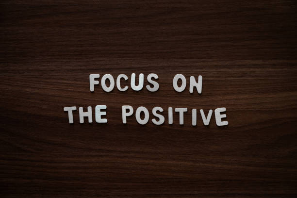 istock Focus on the positive - Wooden letters on walnut background 2200133054