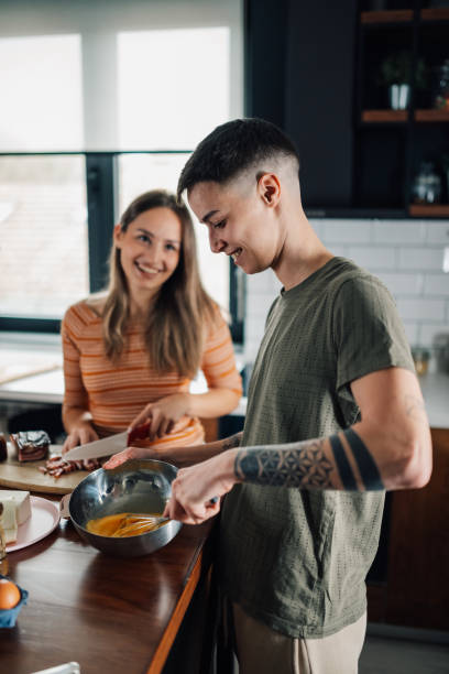 istock Lesbian couple whisking eggs and cutting bacon while preparing breakfast in kitchen 2200133636