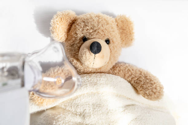 Ill toy bear with nebulizer mask, flu, asthma, pneumonia concept.