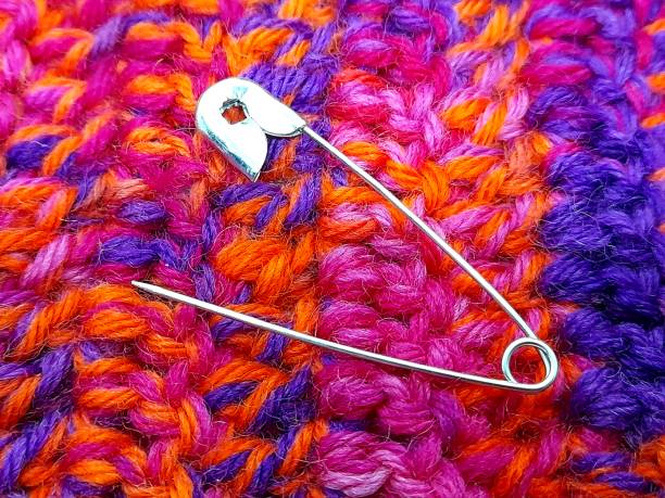 istock Open metal safety pin on knitted fabric. 2200135532