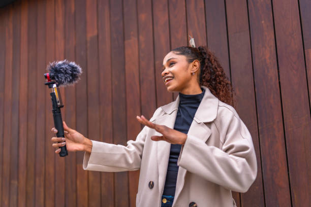 istock Vlogger talking to her audience streaming online next to wall 2200135996