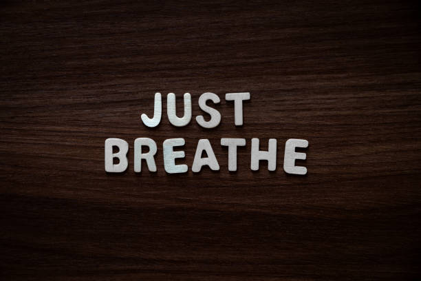 Just breathe - Wooden letters on walnut background