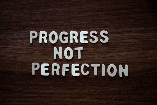 istock Progress not perfection - Wooden letters on walnut background 2200137181