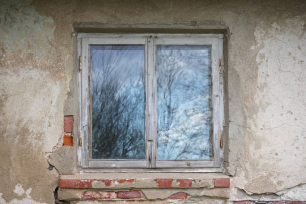 istock .an old wooden window with two panes located on a shabby wall. 2200137184