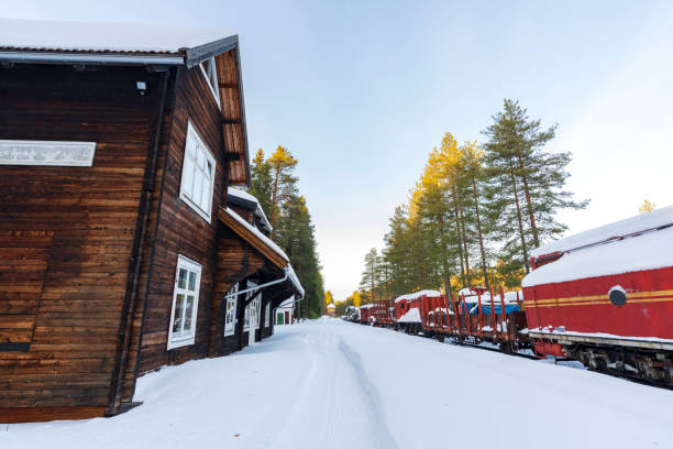 Train station with red carriages on the railway covered with snow in the arctic landscape, Lulea, Swedish Lapland,  Norrbotten, Sweden