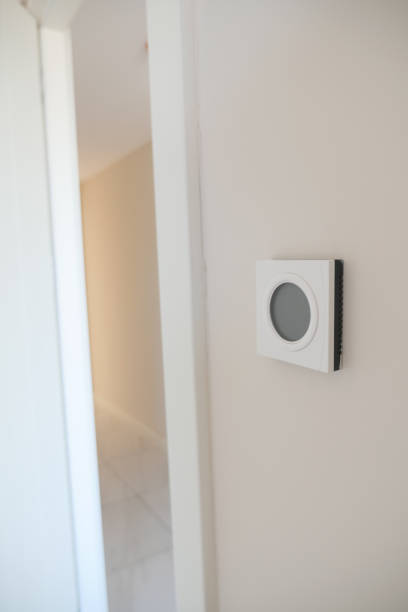istock Smart Thermostat on White Wall for Optimal Home Temperature Control 2200138946