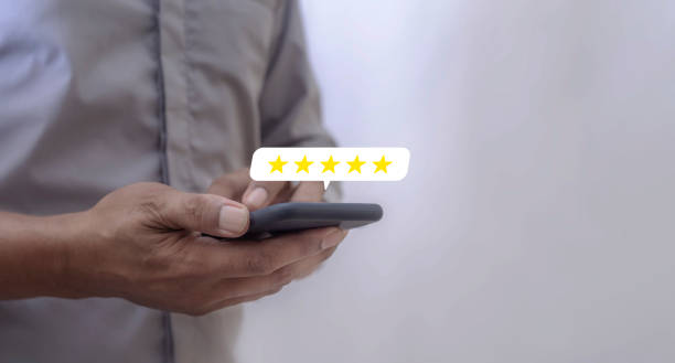 istock Customer Review, Young Man hand using smartphone mobile with five star to review and give 5 stars with very good results in service, Good review 5 star rating choice feedback 2200140345
