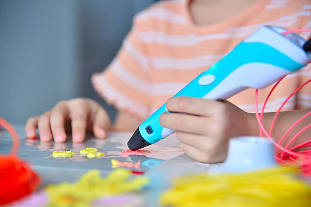 istock Little girl diligently making invention with 3D pen. 2200140419