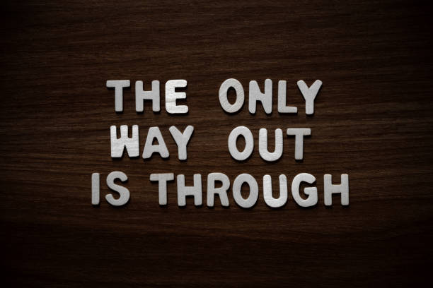 The only way out is through - Wooden letters on walnut background