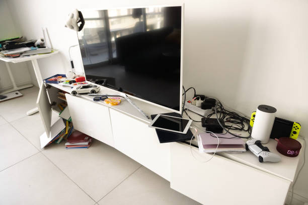 Messy living room with scattered items and gadgets, showcasing the need for space organization.