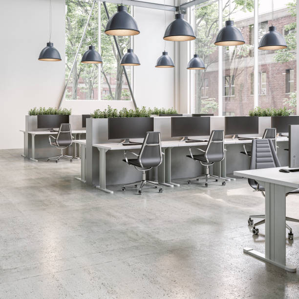 istock Modern office interior with work desks and large windows on cement floor in the morning sun 2200147423