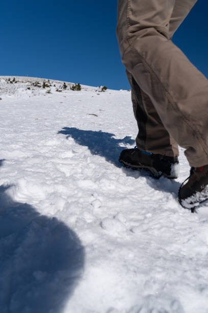 istock Crampons on feet climbing a snowy mountain 2200147613