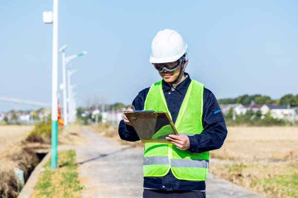 istock Male engineer writing on clipboard with countryside in the background 2200147750